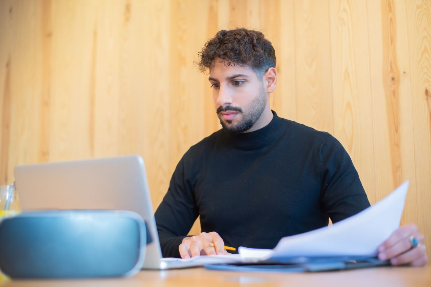 Professional reviewing paperwork and business information on a laptop